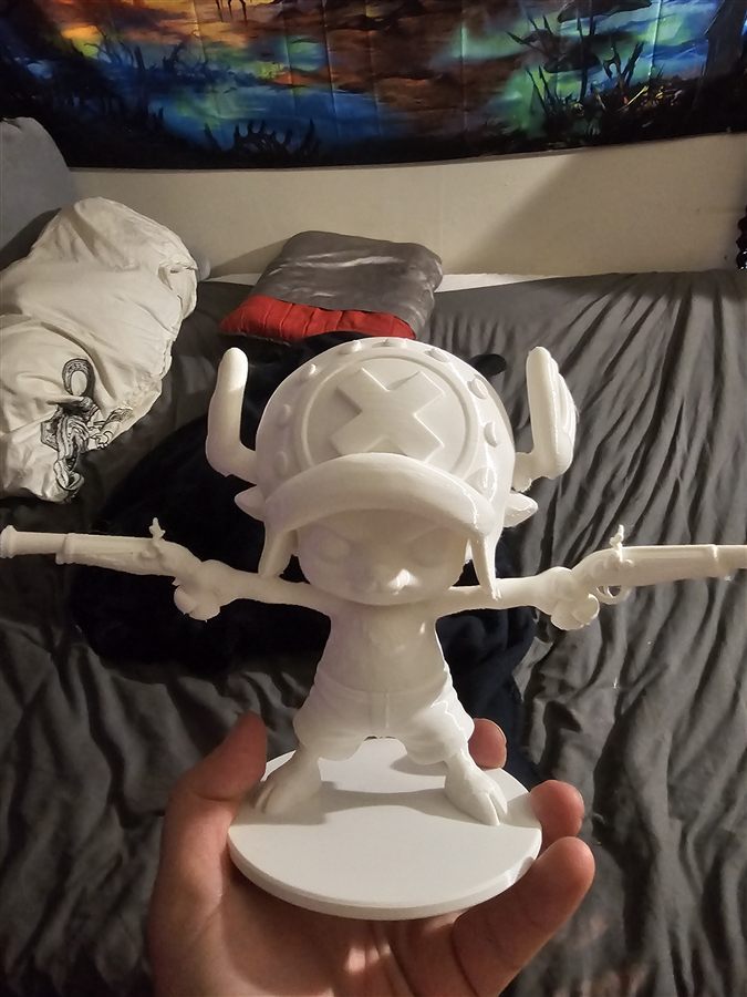 White 3D-printed figure of Chopper from One Piece, dual-wielding two flintlock pistols on a round base