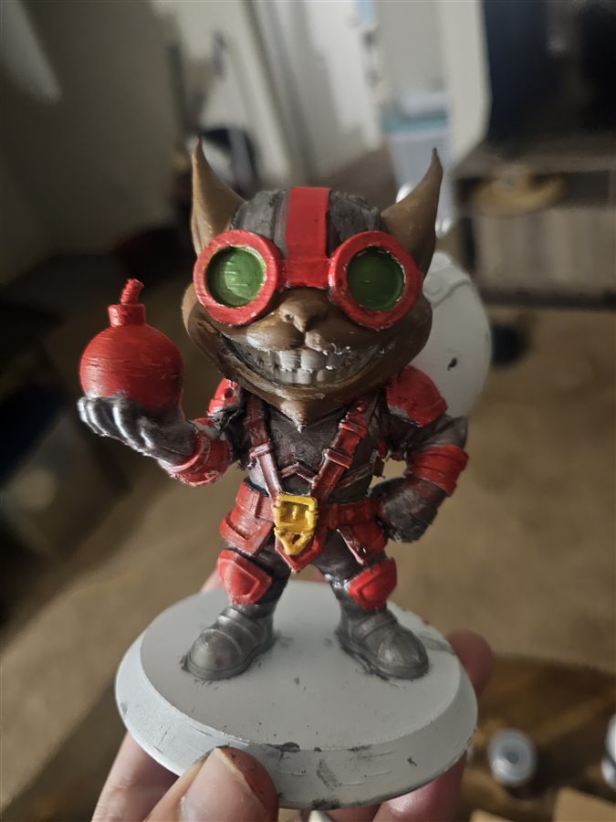 Hand-painted 3D-printed figure of Ziggs from League of Legends, holding a red bomb, with red goggles and armor